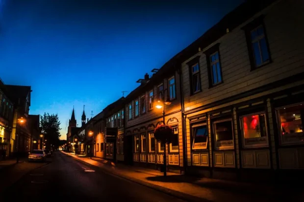 Restaurants_Walsrode_section Historische Altstadt mit Fachwerkhäusern und stimmungsvoller Straßenbeleuchtung in der blauen Stunde bei Nacht.